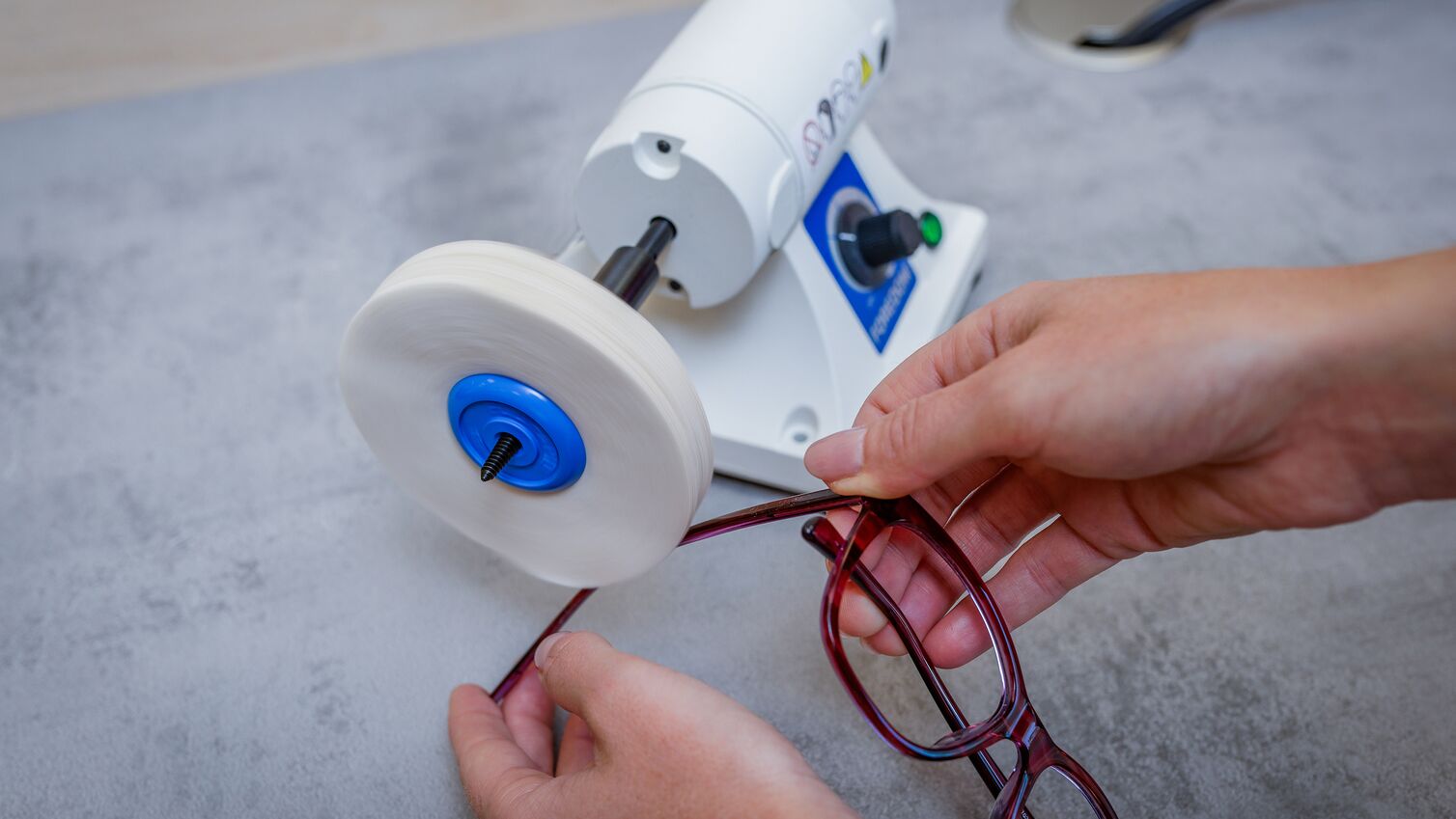 ein Brillenbügel wird mit einem Poliergerät bearbeitet